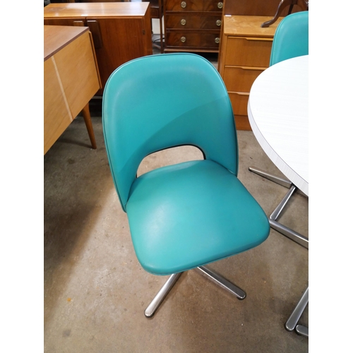 54 - A chrome and Formica circular dining table and four teal vinyl chairs