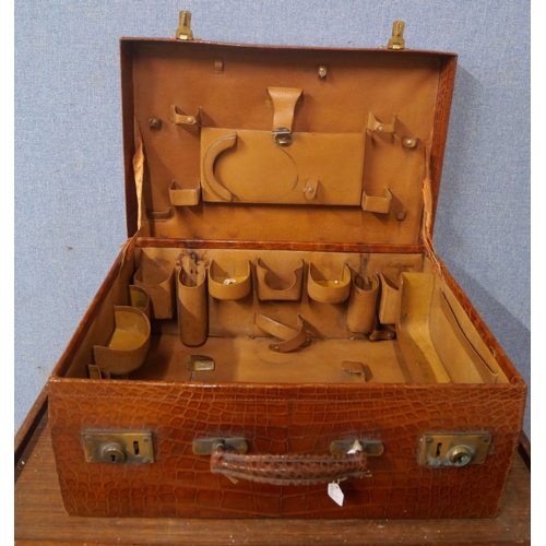 385 - An early 20th Century crocodile skin fitted travelling case