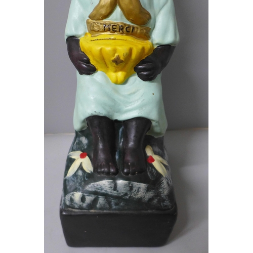 787 - A French charity money box in the form of a seated child with rocking head