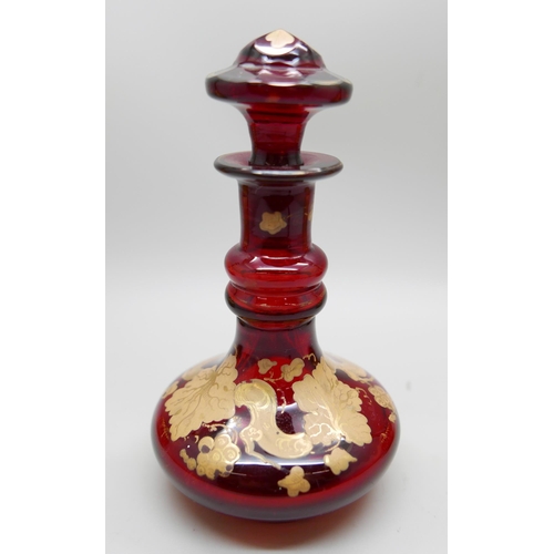 836 - A pair of early 20th Century cranberry glass bottle with lids and gilt detail and a ruby glass scent... 