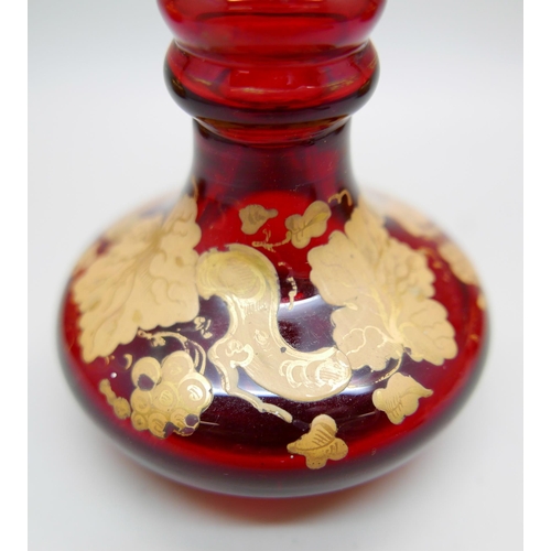 836 - A pair of early 20th Century cranberry glass bottle with lids and gilt detail and a ruby glass scent... 