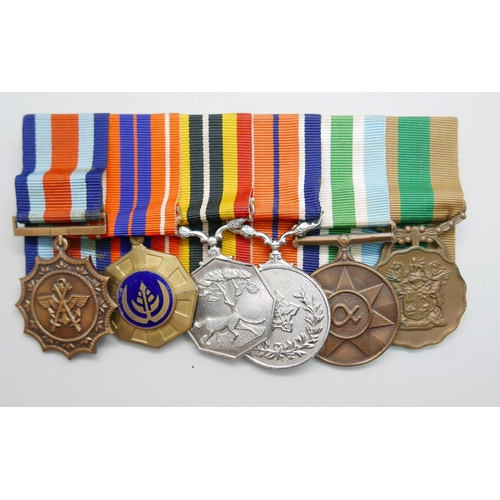 864 - A set of six mounted Rhodesian medals including South African Merit medal, a Pro Patra medal, a Sout... 