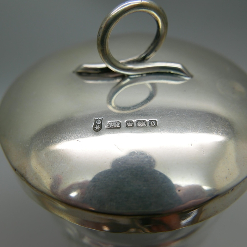 876 - A silver and tortoiseshell hand mirror and a silver topped glass preserve jar, lid 37g