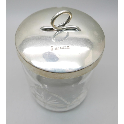 876 - A silver and tortoiseshell hand mirror and a silver topped glass preserve jar, lid 37g