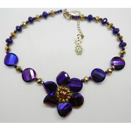 926 - A Butler and Wilson Purple and Gold necklace and a Joules rhinestone three flower necklace