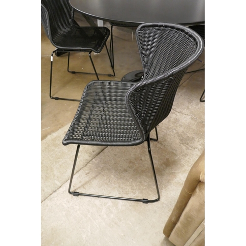 1436 - A Charles and Ray Eames style cast iron based tulip table and Four black woven dining chairs