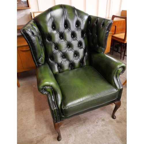 76A - A Thomas Lloyd green leather Chesterfield wingback armchair