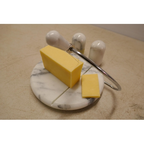 A marble cheese board with salt and pepper pots