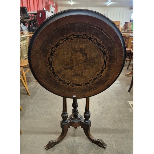 118 - A Victorian Aesthetic Movement marquetry inlaid figured walnut circular tilt top centre table