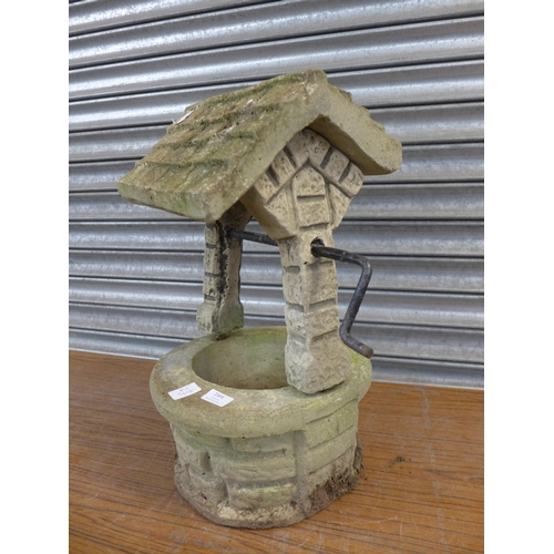 2304 - A concrete wishing well garden ornament