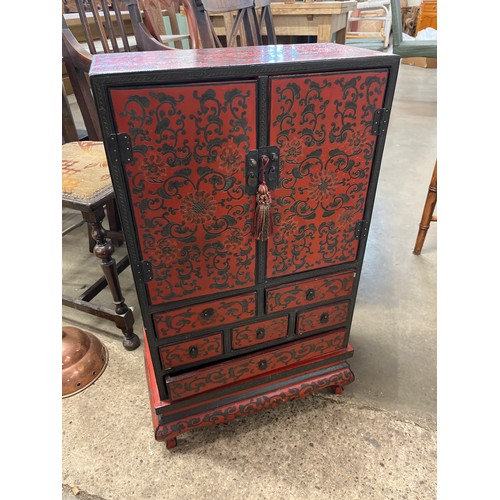 99A - A small oriental red lacquered chinoisiere cabinet