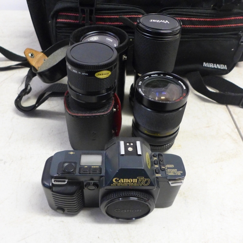 2093 - A Canon T70 35mm camera with quantity of lenses, straps, light meter, etc., all in carry case