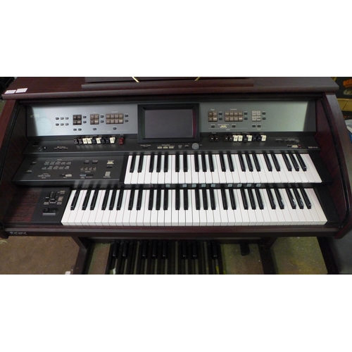 2140 - A Roland Music Atelier AT-500 simulated dark walnut electric organ with stool and sheet music