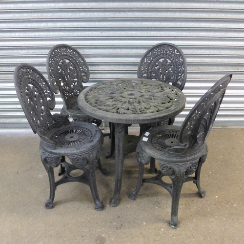 2163 - A black plastic cast iron effect garden table and 4 matching chairs