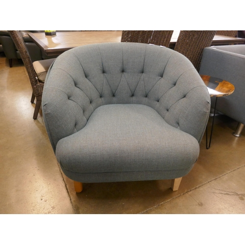 A grey upholstered buttoned armchair