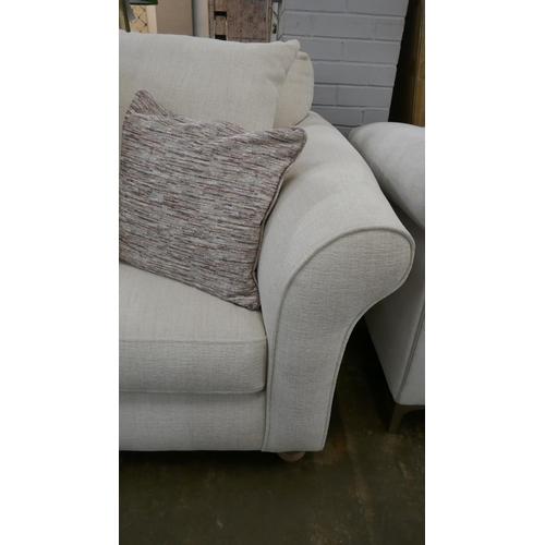 1303 - An oatmeal upholstered three seater sofa