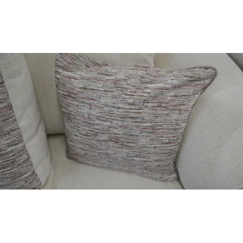 1303 - An oatmeal upholstered three seater sofa