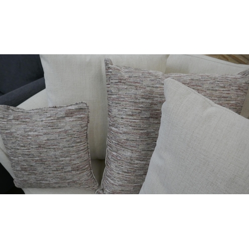 1303 - An oatmeal upholstered three seater sofa