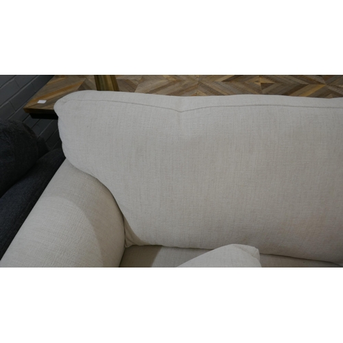 1303 - An oatmeal upholstered three seater sofa