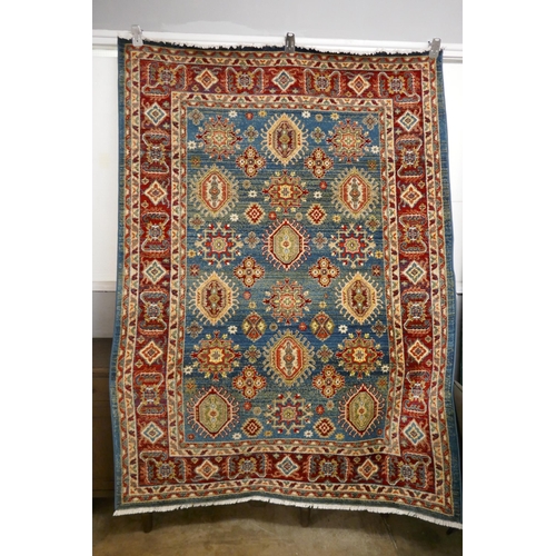 1323 - A blue ground full pile rug with all over Aztec design, 230 x 160cm