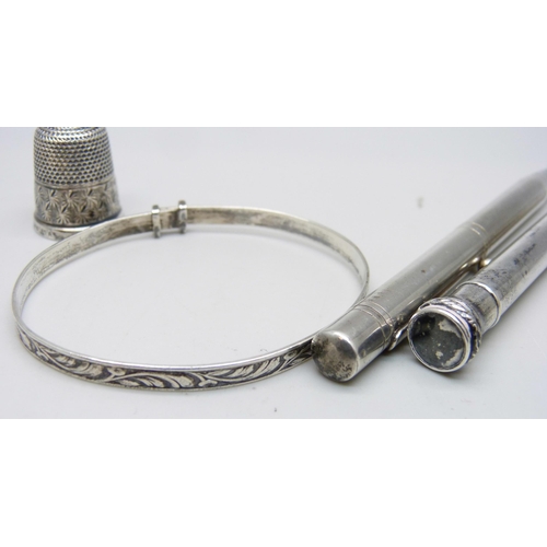 1064 - A hallmarked silver pencil, a plated Evesharp pencil, a silver bangle and a silver thimble