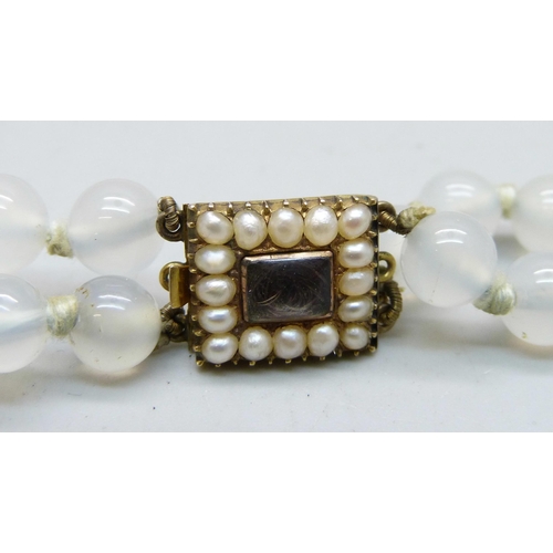 1065 - A selemite double string necklace on a c1900 yellow metal and pearl set clasp with hair memoriam