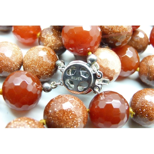 1069 - A heavy faceted goldstone and dark red stone bead double string necklace with silver clasp, 278g