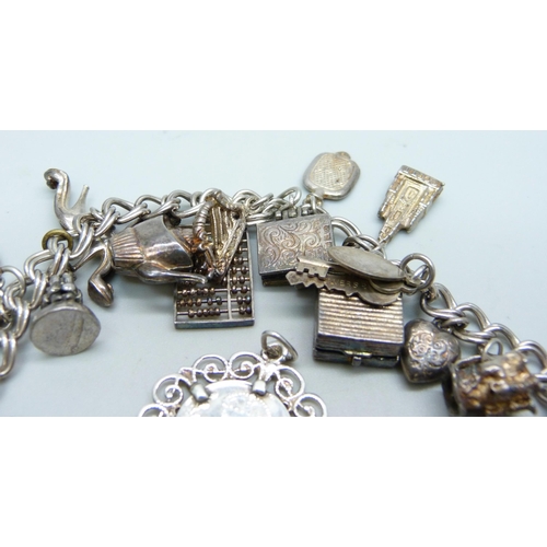 1070 - A silver charm bracelet, two silver pendants and a bracelet, 68g