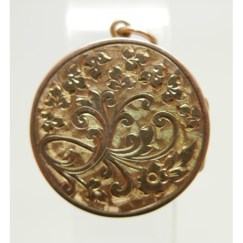 1142 - A yellow metal circular engraved locket, 23mm