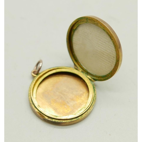 1142 - A yellow metal circular engraved locket, 23mm