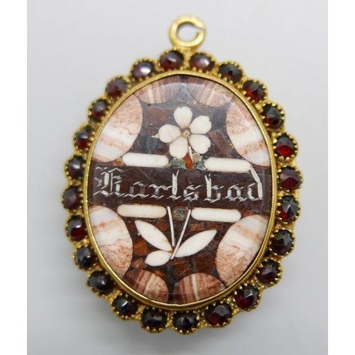 1145 - A gold tone locket with mosaic hardstone spelling Karlsbad, the border set with garnets and the back... 