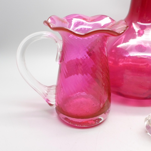 653 - A cranberry glass decanter and two vases