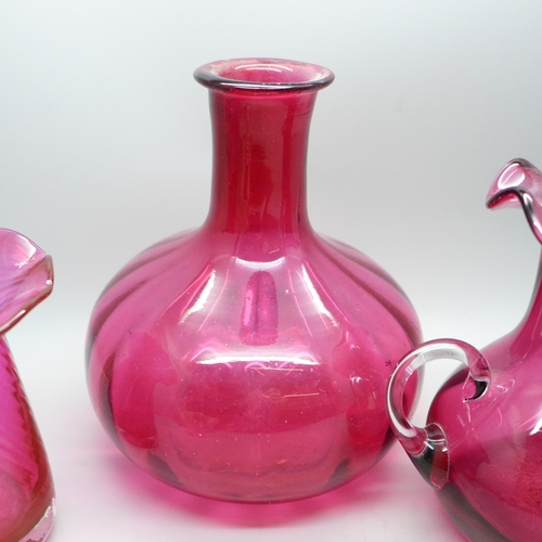 653 - A cranberry glass decanter and two vases