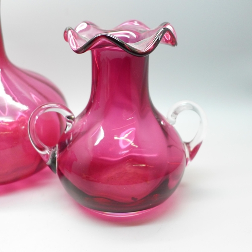 653 - A cranberry glass decanter and two vases