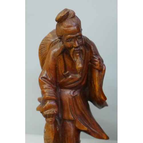 660 - Two carved wooden oriental figures, tallest 21cm, smaller figure with chip to side