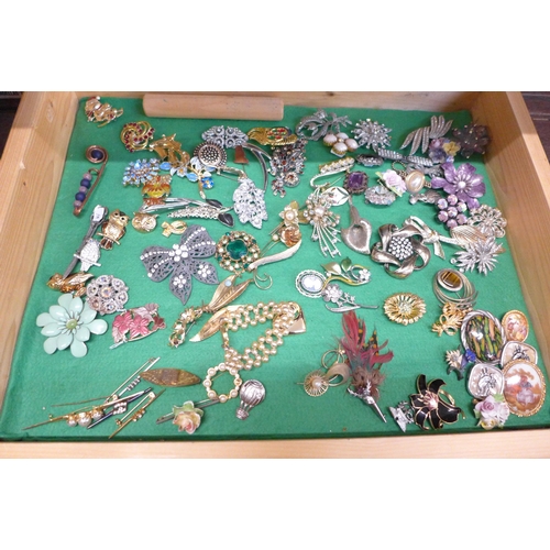 670 - A collection of costume jewellery and brooches in a glass and wooden display case