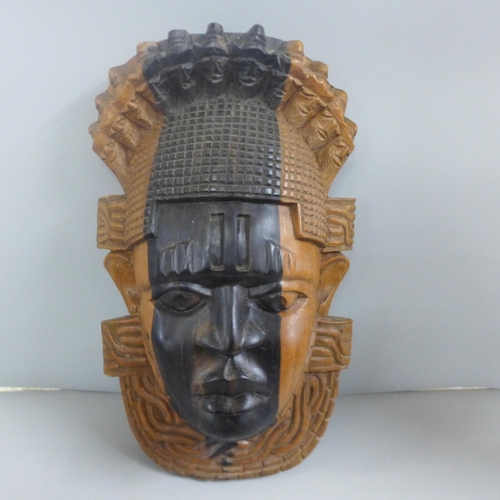 813 - Tribal art; large wall mounted teak carved face mask (37cm tall) and a pair of hardwood turned candl... 