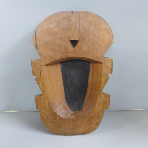 813 - Tribal art; large wall mounted teak carved face mask (37cm tall) and a pair of hardwood turned candl... 