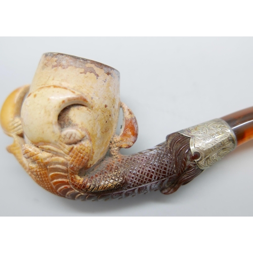 939 - An early 20th Century eagle's claw, pipe, with amber stem and silver collar, cased Meerschaum