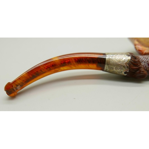 939 - An early 20th Century eagle's claw, pipe, with amber stem and silver collar, cased Meerschaum