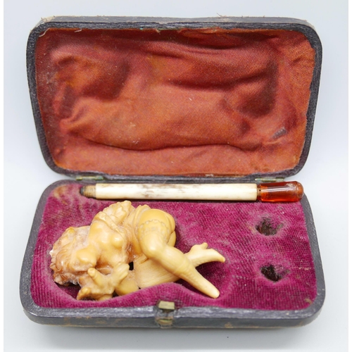 943 - A carved Meerschaum pipe of a scantily clad young lady, with bone stem separate, cased