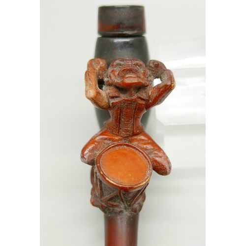 954 - A 19th Century carved Meerschaum pipe depicting a monkey playing a drum, amber stem, cased