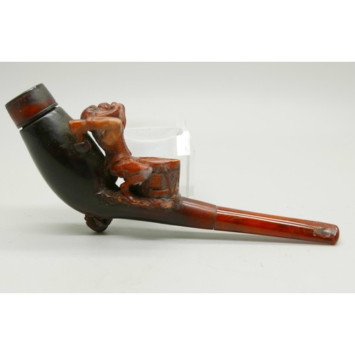 954 - A 19th Century carved Meerschaum pipe depicting a monkey playing a drum, amber stem, cased