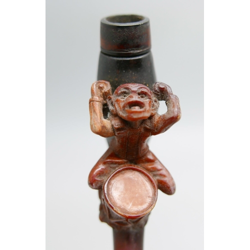 954 - A 19th Century carved Meerschaum pipe depicting a monkey playing a drum, amber stem, cased