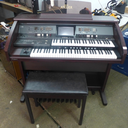 2111 - A Roland Music Atelier (AT-500) simulated dark walnut electric organ with stool and sheet music