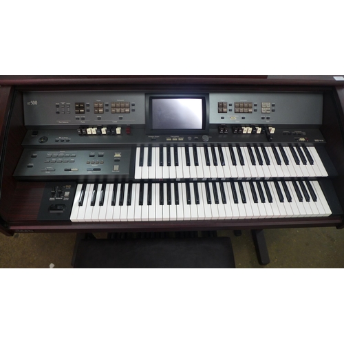 2111 - A Roland Music Atelier (AT-500) simulated dark walnut electric organ with stool and sheet music