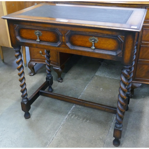 155 - An early 20th Century geometric moulded oak and leather toppwd two drawer barleytwist writing table