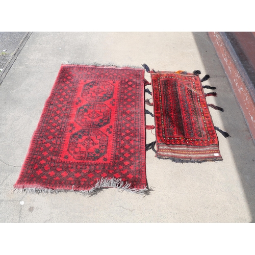 255 - An eastern red ground rug and a Turkish salt bag