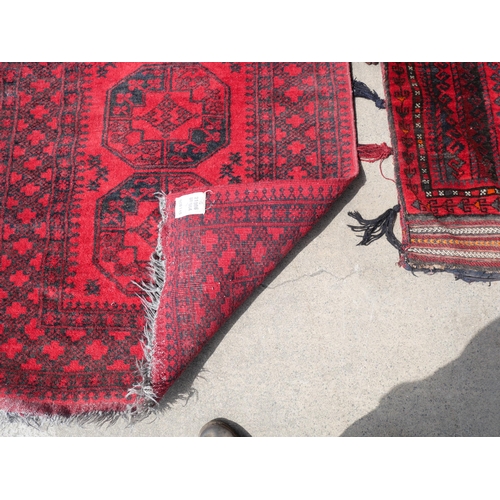 255 - An eastern red ground rug and a Turkish salt bag