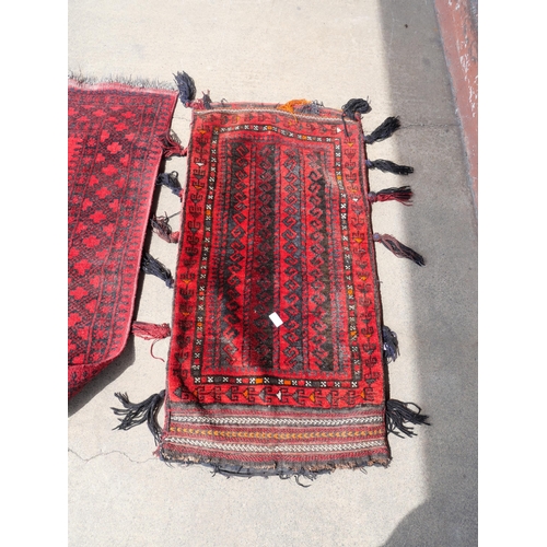 255 - An eastern red ground rug and a Turkish salt bag